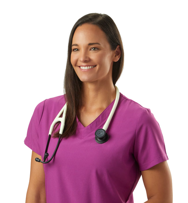 A smiling female healthcare professional wearing magenta scrubs and a 3M™ Littmann® Cardiology IV Diagnostic Stethoscope: Satin Alabaster Tube 6186C around her neck, standing against a white background.