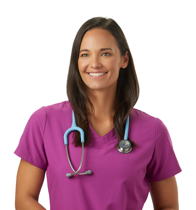 A smiling female nurse in magenta scrubs and a 3M™ Littmann® Classic III Monitoring Stethoscope: Satin Marine Blue Tube 5912C around her neck, standing against a white background.